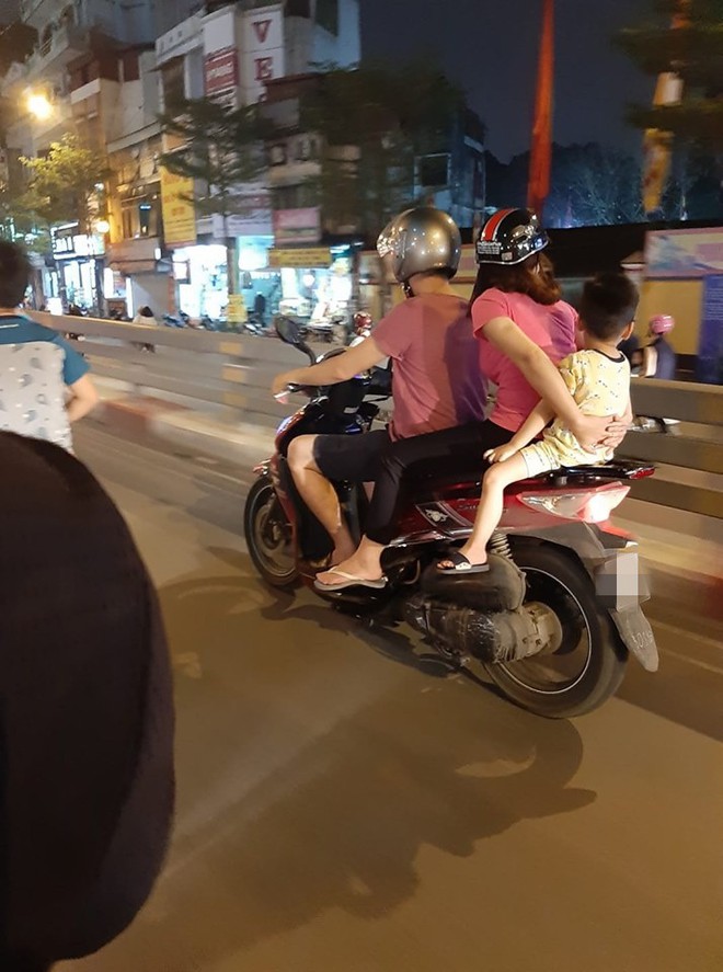 Cả gia đình di chuyển bằng xe máy trên phố Hà Nội - bức ảnh nhận nhiều dấu hỏi nhất tối Chủ nhật  - Ảnh 1.