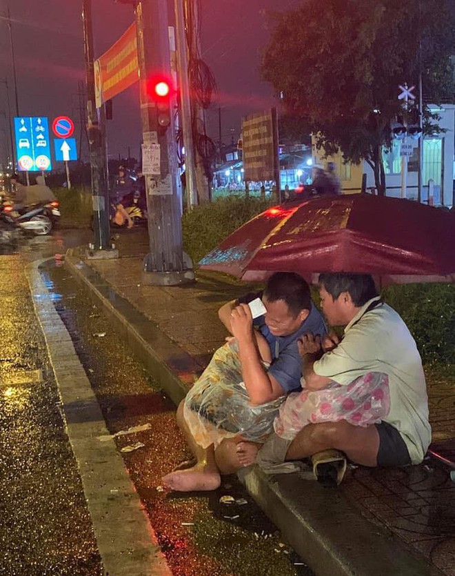 Xúc động cảnh 2 người đàn ông khiếm thị, nương nhau dưới cơn mưa đêm ở Sài Gòn để bán từng tấm vé số mưu sinh - Ảnh 1.