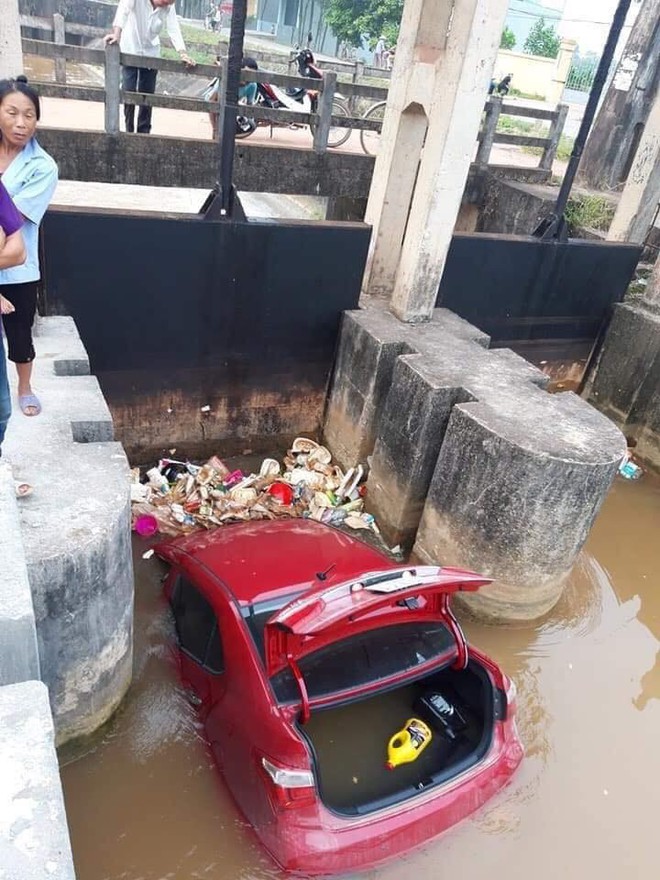 Ô tô màu đỏ nằm dưới mương, rác thải vây xung quanh khiến nhiều người tò mò - Ảnh 2.