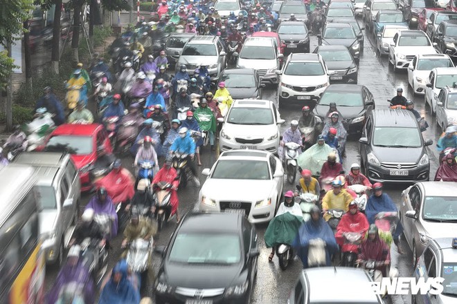 Ảnh: Xe cộ ùn tắc khắp ngả, người dân vất vả mưu sinh dưới trời mưa bão ở Thủ đô - Ảnh 3.
