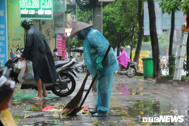 Ảnh: Xe cộ ùn tắc khắp ngả, người dân vất vả mưu sinh dưới trời mưa bão ở Thủ đô - Ảnh 10.