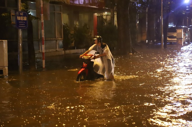 Sau cơn mưa suốt đêm, nhiều nơi ở Hà Nội chìm trong biển nước, cây lớn đổ đè một phần taxi - Ảnh 9.