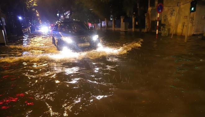 Sau cơn mưa suốt đêm, nhiều nơi ở Hà Nội chìm trong biển nước, cây lớn đổ đè một phần taxi - Ảnh 8.