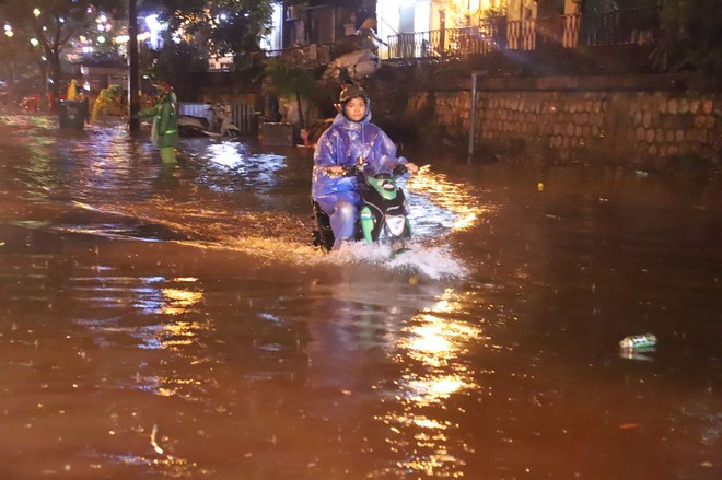 Sau cơn mưa suốt đêm, nhiều nơi ở Hà Nội chìm trong biển nước, cây lớn đổ đè một phần taxi - Ảnh 4.