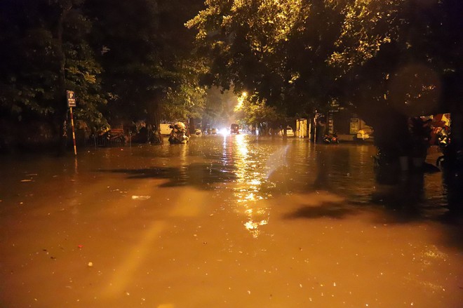 Sau cơn mưa suốt đêm, nhiều nơi ở Hà Nội chìm trong biển nước, cây lớn đổ đè một phần taxi - Ảnh 5.