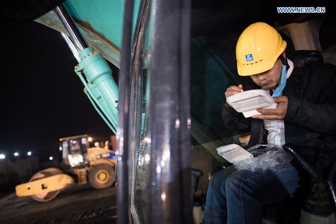 24h qua ảnh: Công nhân ăn cơm trên máy xúc để kịp xây bệnh ở Vũ Hán - Ảnh 2.