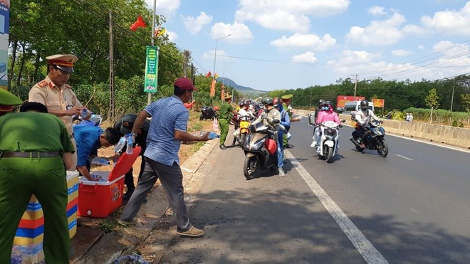 Công an Đồng Nai đội nắng phát nước, khăn lạnh cho người dân giao thông ngày Tết - Ảnh 3.