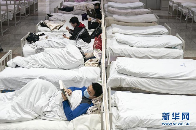Bệnh viện cabin vuông 1.600 giường đầu tiên ở Vũ Hán đi vào hoạt động, bệnh nhân bình thản đọc sách - Ảnh 9.