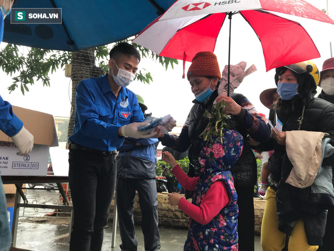 Người dân bỏ làm, đội mưa lạnh đứng đợi nhận khẩu trang miễn phí tại chợ thuốc lớn nhất Hà Nội - Ảnh 6.