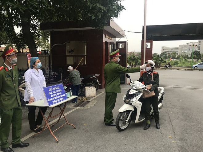 Công an Long Biên kiểm tra thân nhiệt, phát khẩu trang miễn phí cho cán bộ, người dân đến làm việc - Ảnh 1.