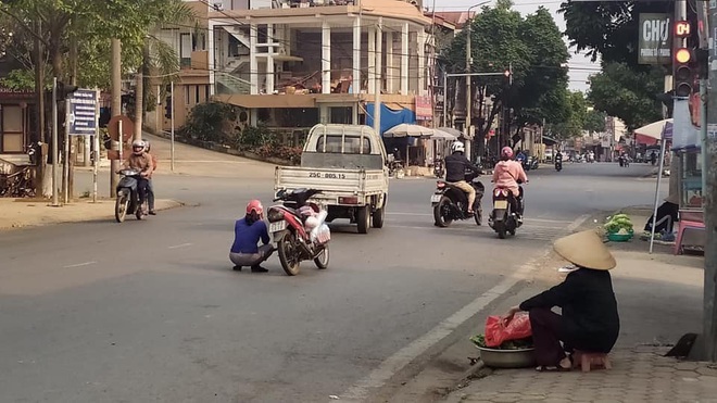 Người phụ nữ dừng xe máy ngồi giữa đường, hành động sau đó của chị khiến ai cũng kinh ngạc  - Ảnh 1.