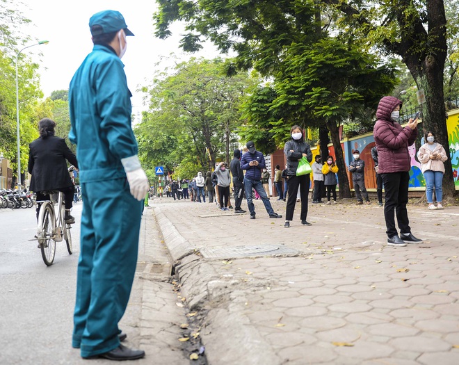 Hàng trăm người dân xếp hàng đợi xét nghiệm nhanh COVID-19 có kết quả trong 10 phút ở Hà Nội - Ảnh 1.