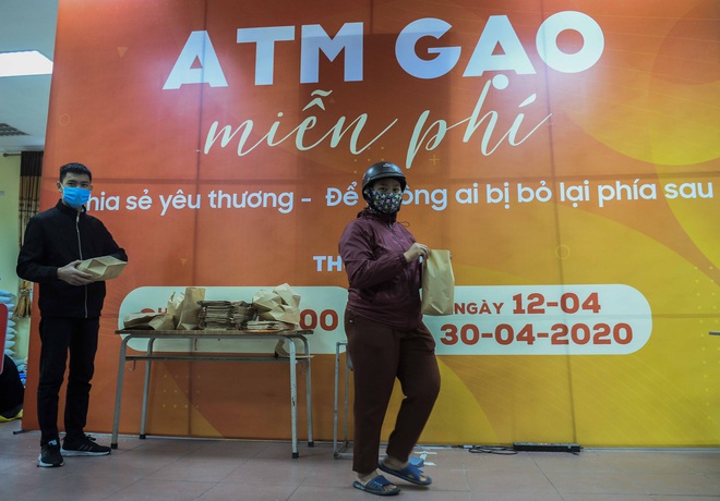 [Ảnh] Nhiều người đội mưa đến nhận gạo tại cây ATM gạo miễn phí ở Hà Nội - Ảnh 1.