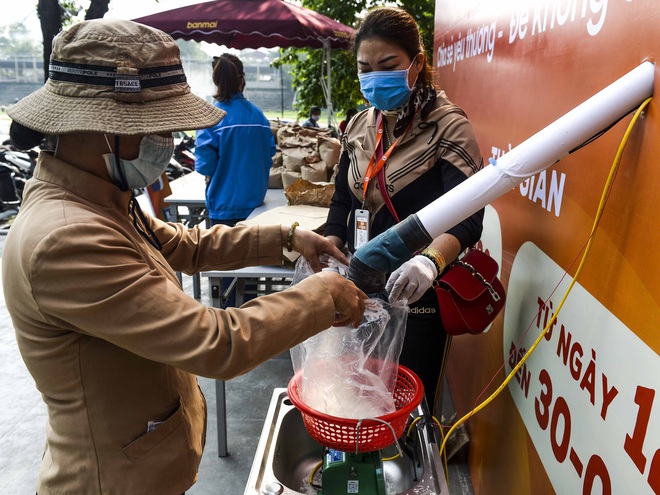 [Ảnh] Người dân xếp hàng kéo dài từ sân vận động đến sân nhà văn hoá ở Hà Nội đợi nhận gạo từ cây ATM gạo miễn phí  - Ảnh 1.