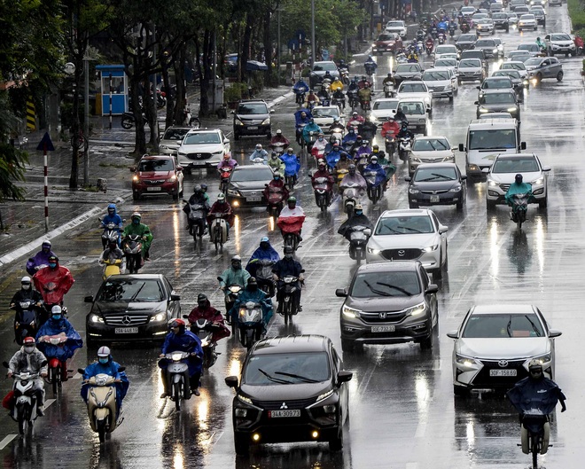 Hà Nội ngày đầu hết cách ly xã hội: Người dân đổ ra đường đi làm dưới cơn mưa tầm tã - Ảnh 1.
