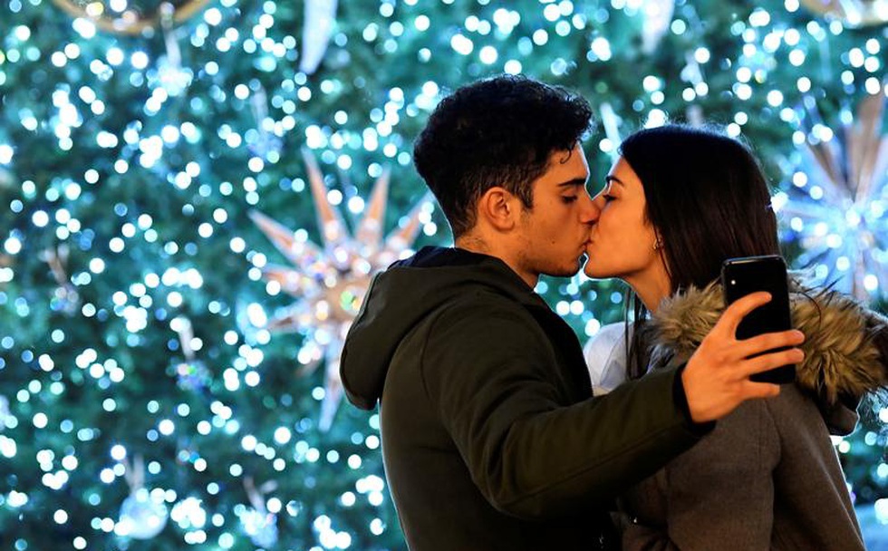Cặp tình nhân hôn nhau trong ánh đèn lung linh vào dịp Giáng sinh ở thành phố Milan, Italia. Ảnh: Reuters