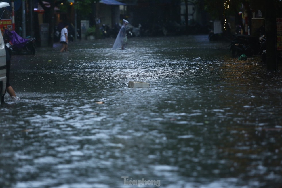 Bị mưa lớn đánh úp giữa trưa, nhiều tuyến phố Hà Nội ngập sâu nửa mét - Ảnh 10.