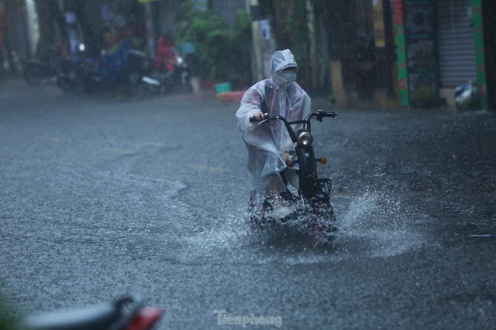 Bị mưa lớn đánh úp giữa trưa, nhiều tuyến phố Hà Nội ngập sâu nửa mét - Ảnh 1.