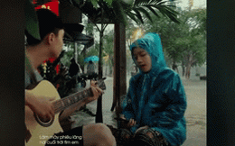 Dân mạng truy tìm danh tính cô gái Huế mặc áo mưa ngồi đàn hát giữa trời mưa ngập lụt