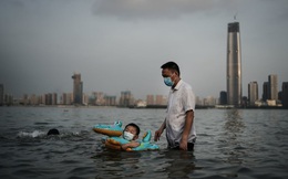 24h qua ảnh: Cậu bé đeo khẩu trang bơi trong công viên ngập lụt do nước sông dâng cao ở TQ
