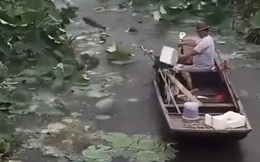 Ung dung đi thuyền giữa hồ, người đàn ông bỗng 'vớ bở' với đàn cá