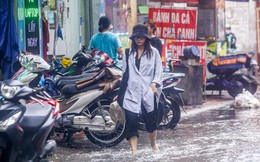 Người dân bì bõm về nhà trên những con phố ngập nước ở Hà Nội