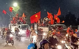 Đoàn người ngồi trên xe tải phấn khích giơ tay chào nhau, hô vang "Việt Nam vô địch"