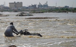 24h qua ảnh: Người đàn ông Pakistan cố "cứu" chiếc mô-tô khỏi dòng lũ