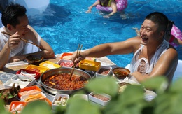 Thời tiết nóng nực, người dân Trung Quốc tràn xuống bể bơi ngồi ăn lẩu siêu cay