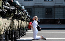 24h qua ảnh: Người phụ nữ quỳ trước hàng rào cảnh sát chống bạo động ở Belarus