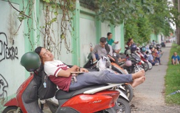 CẬP NHẬT: Thí sinh làm bài thi môn Văn, phụ huynh tranh thủ chợp mắt trên xe máy chờ con