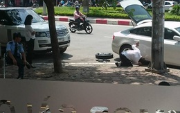 Chồng mặc đồ bảnh bao, cúi người thay lốp xe giữa đường giúp vợ