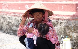 Người người đi lễ trong mùa Phật Đản, riêng em theo mẹ bán hàng rong trước cổng chùa