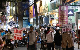 Nhiều nhân viên cửa hàng thời trang ở Sài Gòn cầm bảng giá tràn ra đường chào mời khách dịp cận Tết