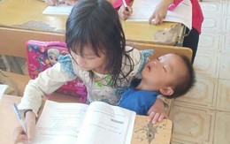 Vừa bế em vừa học bài, tấm hình chụp cô bé tiểu học khiến nhiều người xót xa