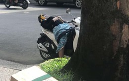 Người phụ nữ mặc đồ chống nắng, vô tư ngả lưng ngủ giữa đường trên xe SH khiến cư dân mạng thích thú