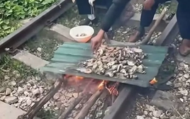 Xử phạt cặp vợ chồng ngồi trên đường ray tàu nướng đồ ăn