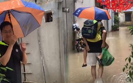 Nhiều tuyến phố Hà Nội ngập sâu, bố lội nước 3 lượt cõng con đến lớp
