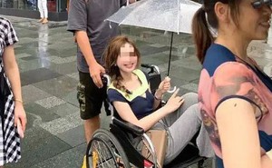 Ồn ào cảnh cô gái đi mua sắm bằng xe lăn chỉ để chân không dính mưa
