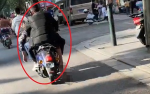 Người đàn ông điều khiển xe máy chở thi thể ngay trên đường phố, chân người chết bị kéo lê suốt dọc đường