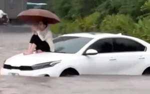 Đường Hà Nội có nơi ngập gần 1m trong sáng nay, người dân ngồi lên nóc xe chờ nước rút