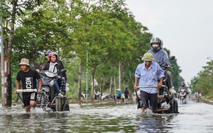 Người dân qua đại lộ Thăng Long bỏ 50.000 đồng/lượt xe bò để ‘vượt ngập’