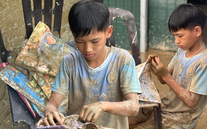 Cậu bé 12 tuổi lật từng trang sách lấm bùn sau lũ quét ở Nghệ An: “Chữ vẫn còn đọc được cô ạ!”