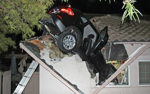 24h qua ảnh: Xe ô tô mất lái "hạ cánh" xuống mái nhà ở Mỹ