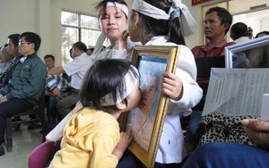 Xúc động bức ảnh cháu bé hôn di ảnh người cha chết do nhục hình