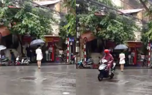 Lạ lùng thiếu nữ váy trắng đứng 4 tiếng giữa phố mưa Hà Nội
