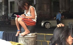 Bé gái mải mê làm bài tập trên đường phố gây sốt trên mạng xã hội