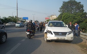 Xe Lexus hất văng 2 người đi xe máy ngã xuống đường