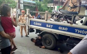 Nam thanh niên nằm ôm bánh xe ô tô của CSGT để "ăn vạ"
