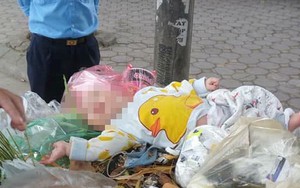 Trước khi bé trai được phát hiện ở thùng rác, một phụ nữ trên 30 tuổi bế bé, nhận là mẹ